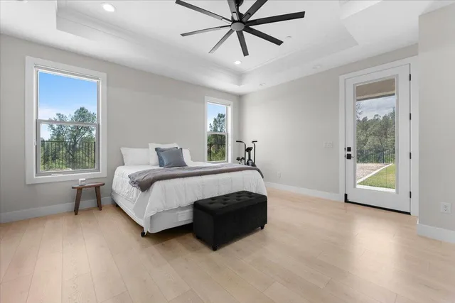 a spacious bedroom with a bed and wooden floor