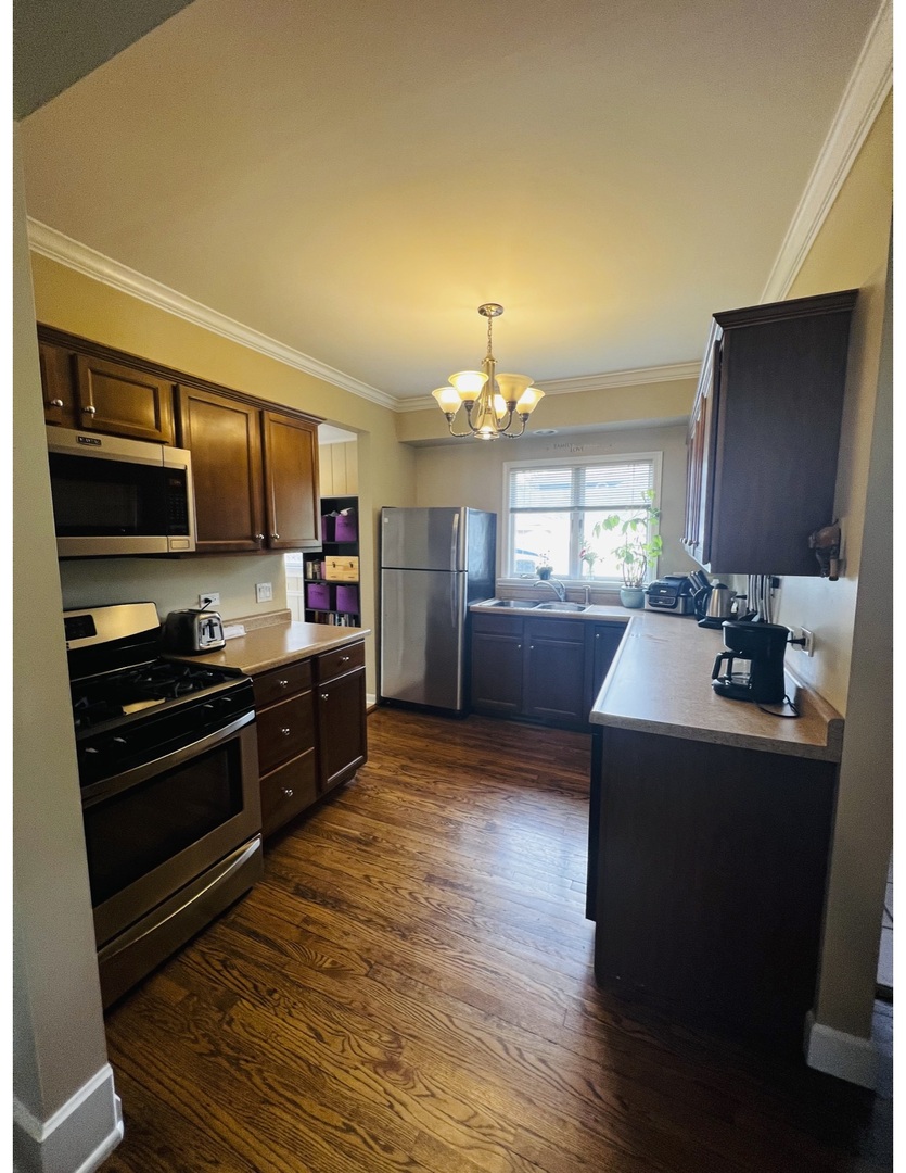 205 West Harrison Road Lombard, IL 60148 - Photo 17 of 26 a kitchen with stainless steel appliances granite countertop a stove top oven a sink dishwasher a dining table and chairs with wooden floor