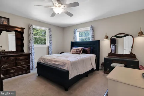 a bedroom with a bed and a flat tv screen on the dresser