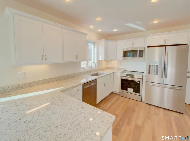 a kitchen with a refrigerator sink and cabinets