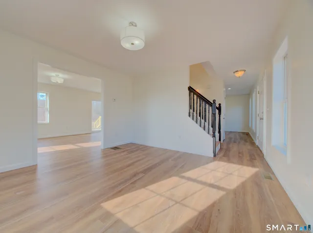 a view of a big room with wooden floor and stairs