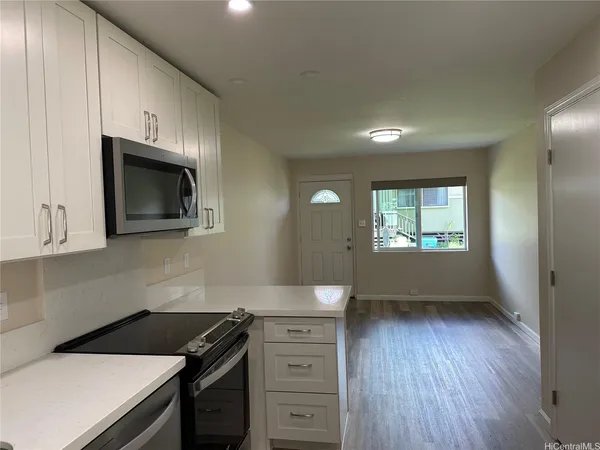 a kitchen with a wooden floor and a stove top oven