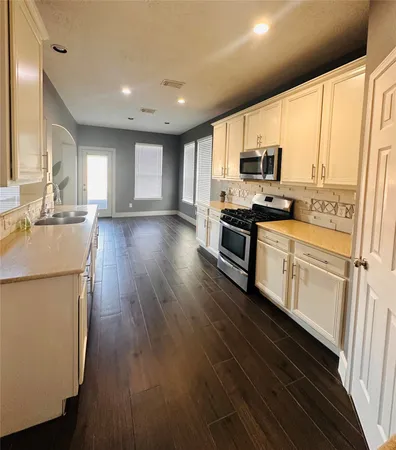 a kitchen with stainless steel appliances a stove top oven a sink a refrigerator a window