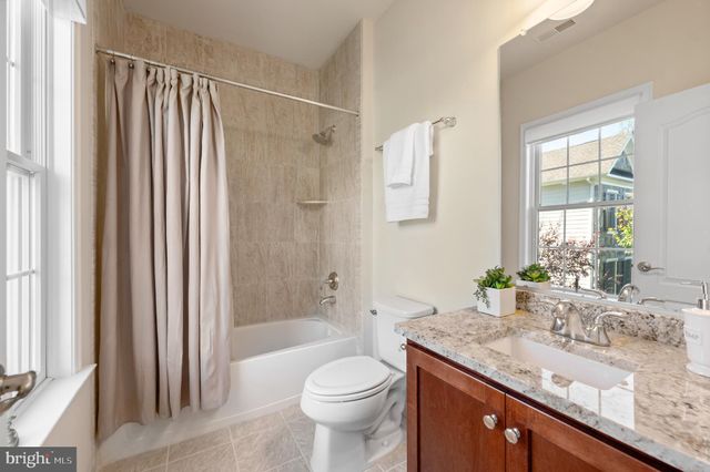 a bathroom with a granite countertop sink and a toilet