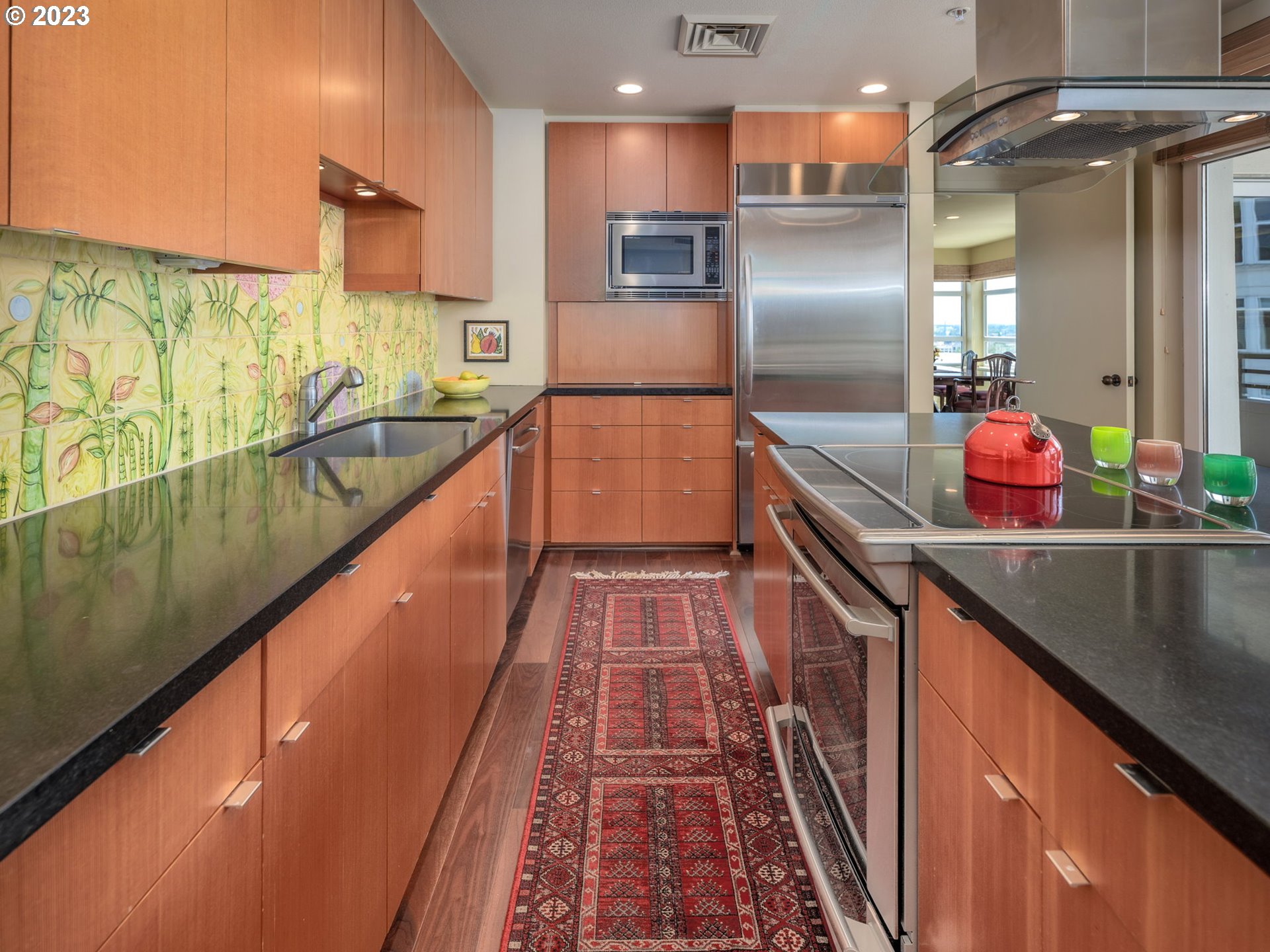 2445 Northwest Westover Road, Unit 411 Portland, OR 97210 - Photo 18 of 38 a kitchen with stainless steel appliances granite countertop a sink and wooden cabinets