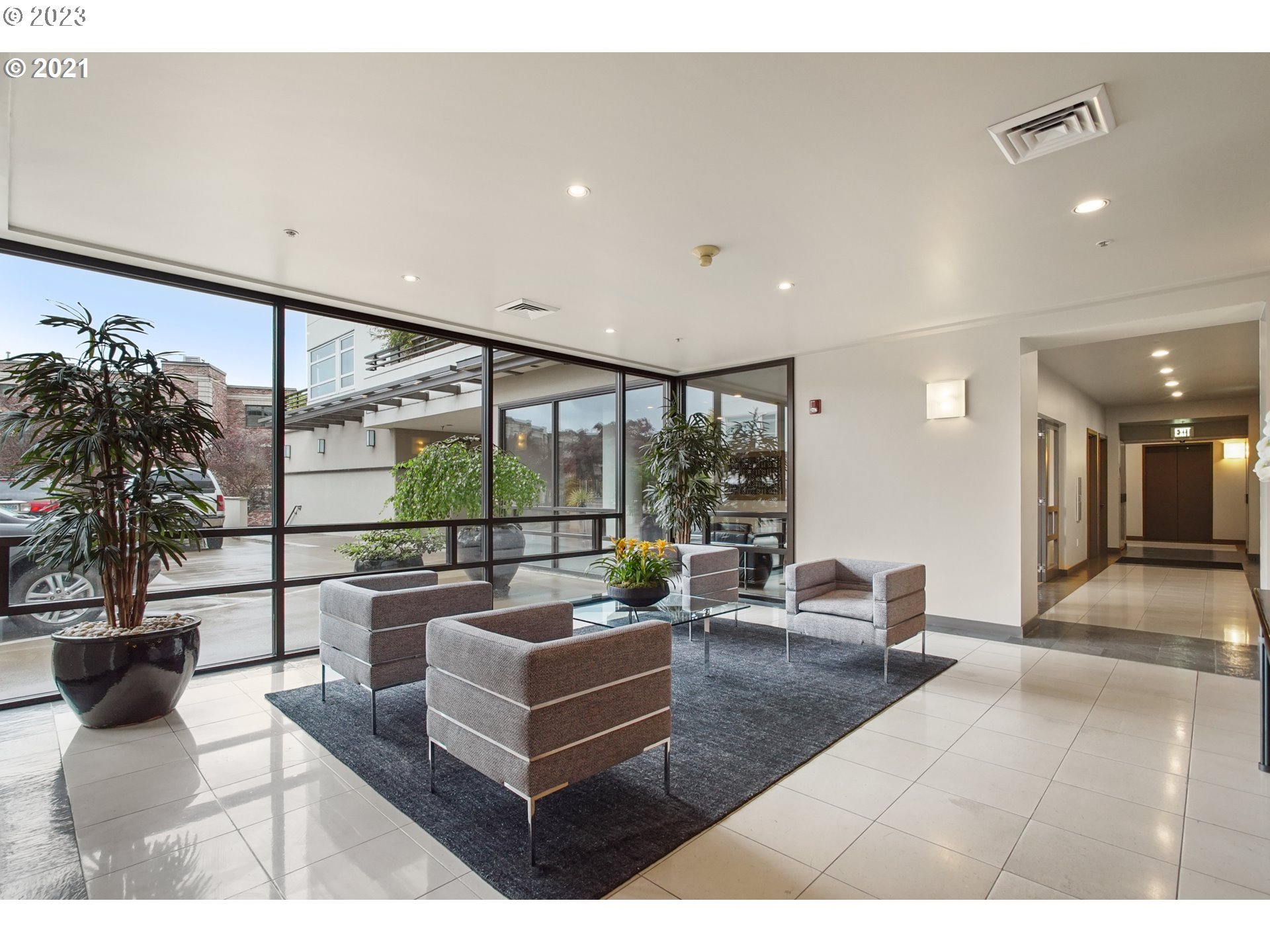 2445 Northwest Westover Road, Unit 411 Portland, OR 97210 - Photo 36 of 38 a living room with furniture large window and palm tree