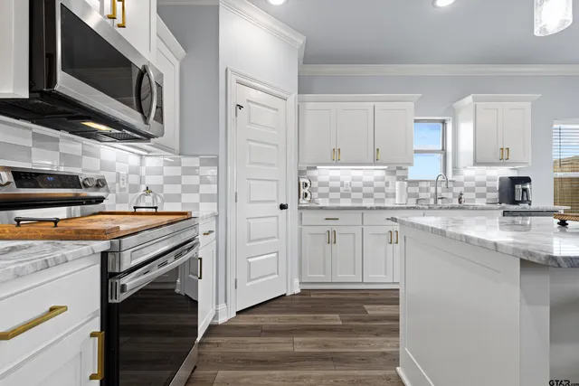 a kitchen with stainless steel appliances granite countertop a stove microwave and cabinets