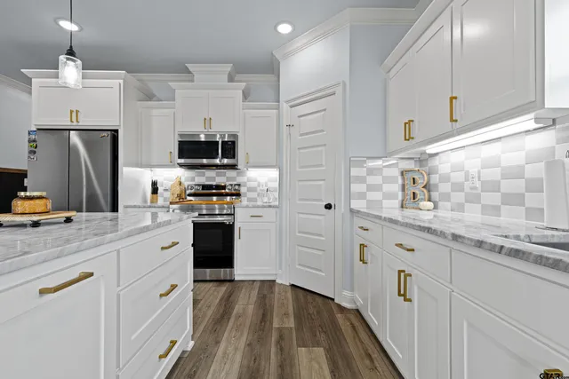 a kitchen with stainless steel appliances a refrigerator sink and cabinets
