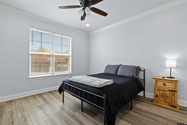 a bedroom with a bed and wooden floor