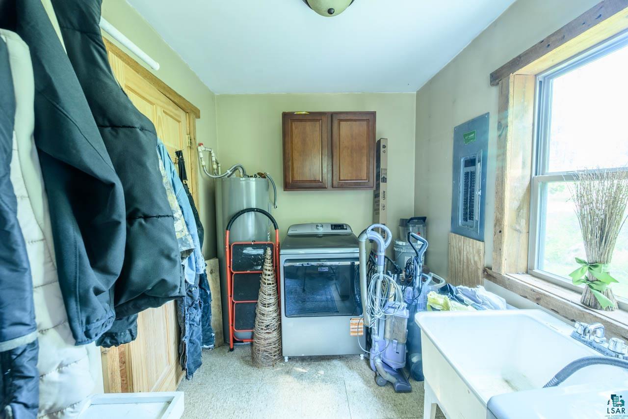 7603 Levander Road Embarrass, MN 55732 - Photo 15 of 51 Utility room featuring a built-in laundry sink, window with natural wood trim, overhead lighting, and wall-mounted cabinetry