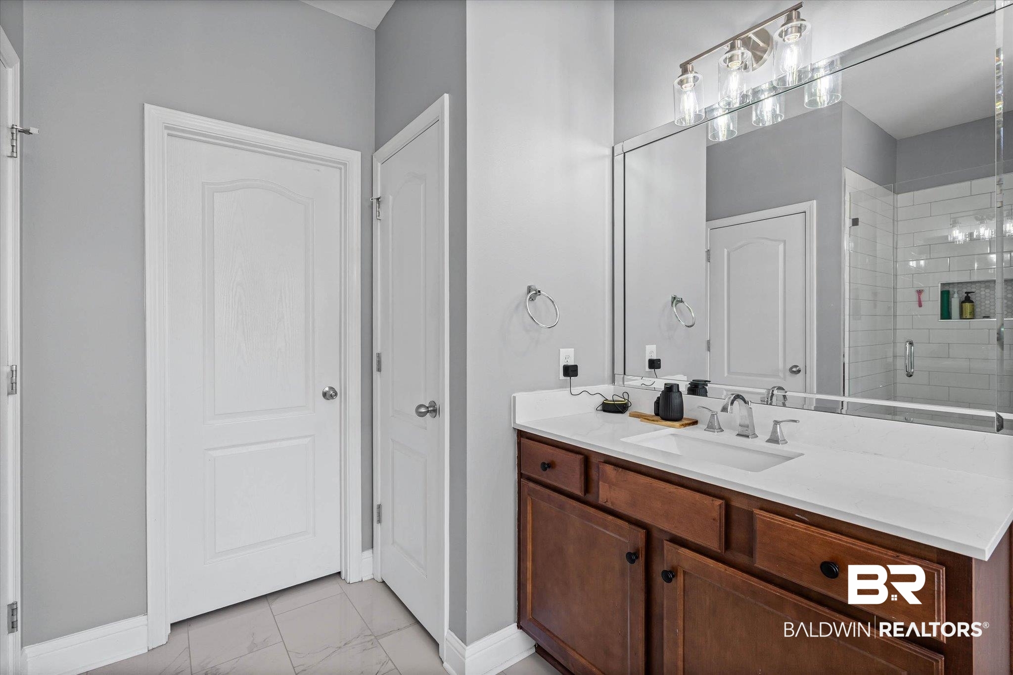 3739 Whitestone Drive Semmes, AL 36575 - Photo 15 of 25 Bathroom vanity featuring a white countertop with an undermount sink, brushed nickel faucet, and a large mirror