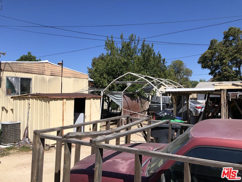 32886 Wildomar Trail Wildomar, CA 92595 - Photo 14 of 22 a view of a patio with table and chairs under an umbrella with a small yard