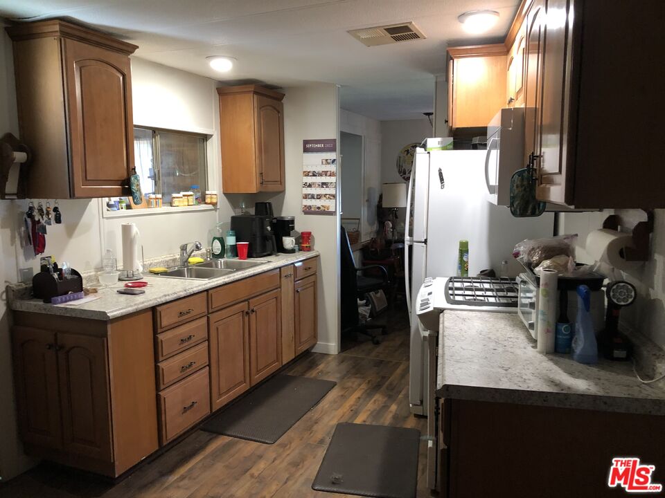 32886 Wildomar Trail Wildomar, CA 92595 - Photo 6 of 22 a kitchen with sink refrigerator and microwave