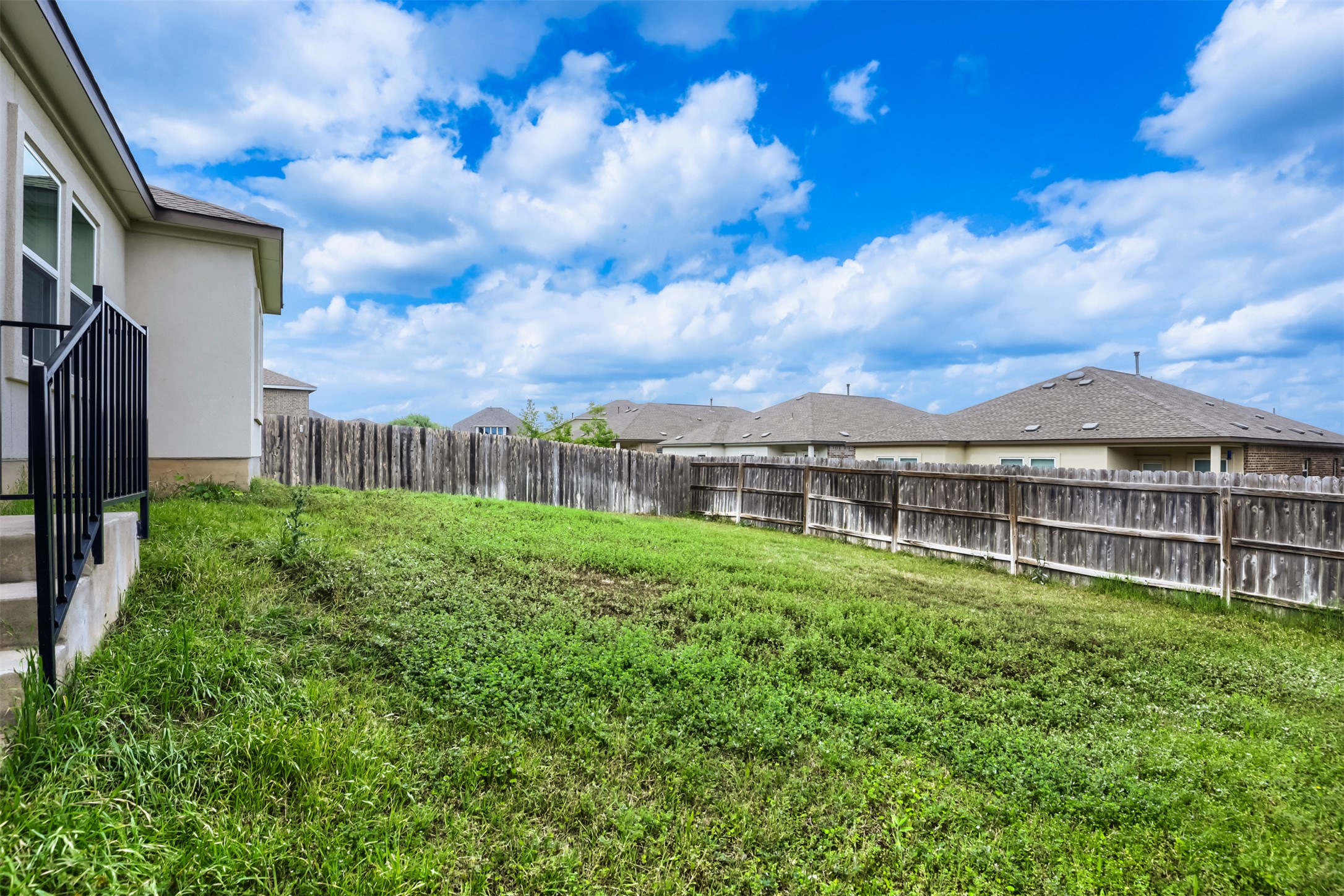 721 Mallow Road Leander, TX 78641 - Photo 21 of 22 The property features a spacious backyard with a wooden privacy fence and a grassy lawn