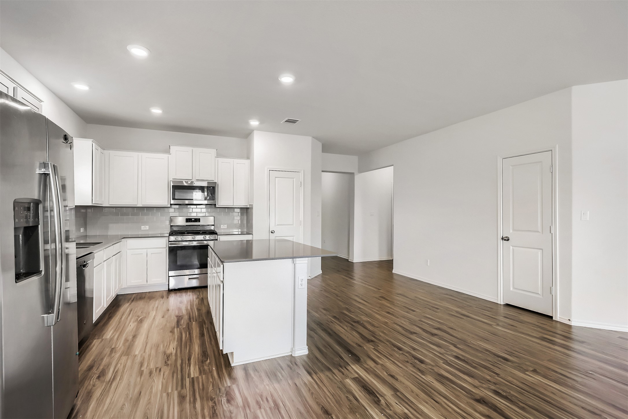 721 Mallow Road Leander, TX 78641 - Photo 8 of 22 This property features an open-concept living area with wood-look flooring throughout