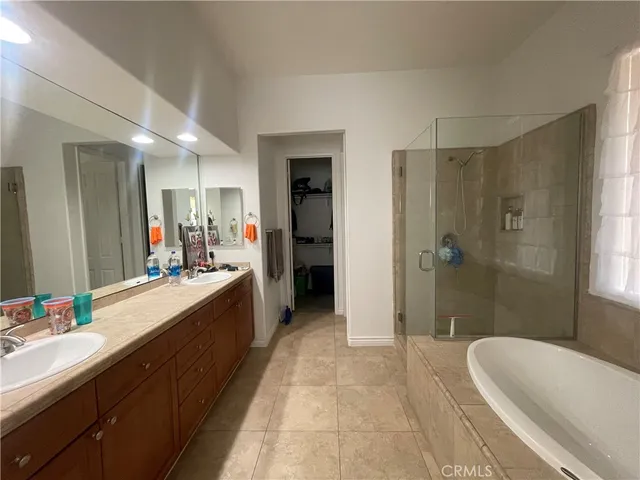 a large bathroom with a tub sink shower and mirror