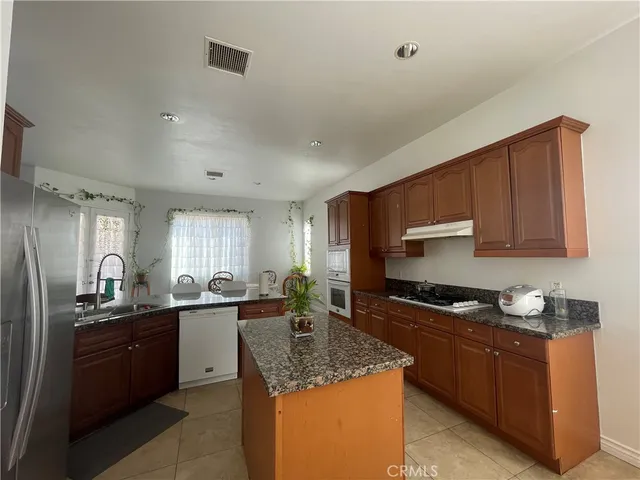 a kitchen with stainless steel appliances granite countertop a sink stove and cabinets