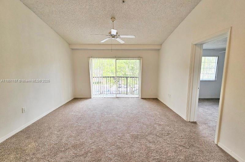 4149 Haverhill Road, Unit 1608 West Palm Beach, FL 33417 - Photo 1 of 29 an empty room with chandelier fan and windows