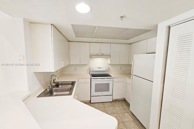 4149 Haverhill Road, Unit 1608 West Palm Beach, FL 33417 - Photo 4 of 29 a kitchen with a stove a refrigerator and a sink