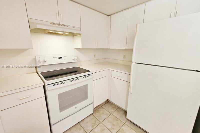 4149 Haverhill Road, Unit 1608 West Palm Beach, FL 33417 - Photo 6 of 29 a kitchen with stainless steel appliances white cabinets and a refrigerator