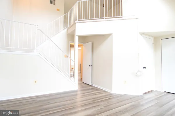 a view of a hallway with wooden floor and staircase