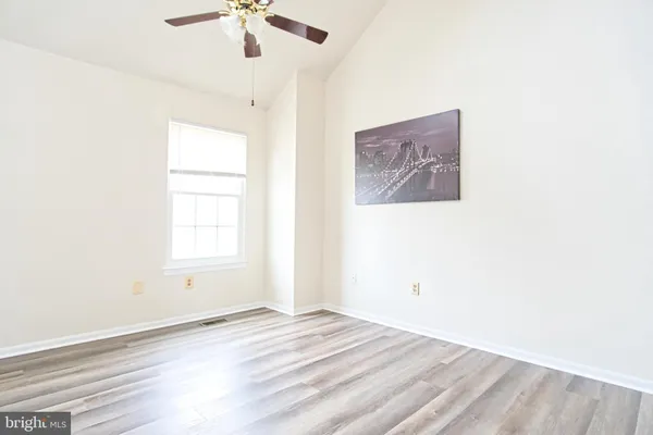 an empty room with a window and a ceiling fan