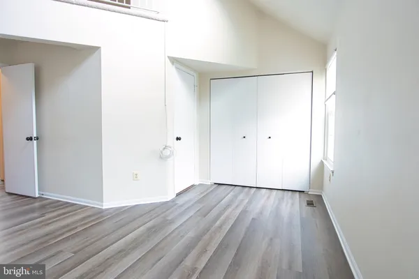 a view of an empty room with wooden floor