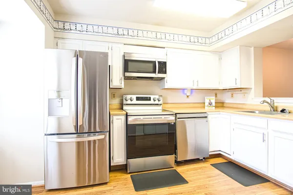 a kitchen with stainless steel appliances a stove microwave and a refrigerator