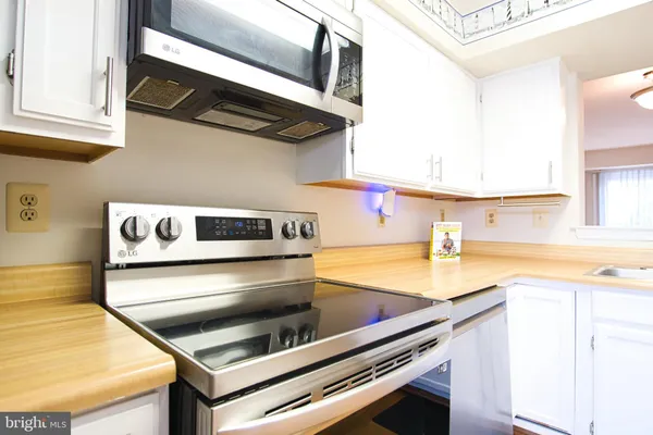 a kitchen with kitchen island a stove and a sink
