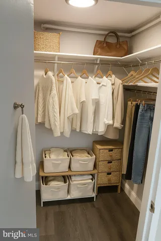 a view of walk in closet with clothes and shoes