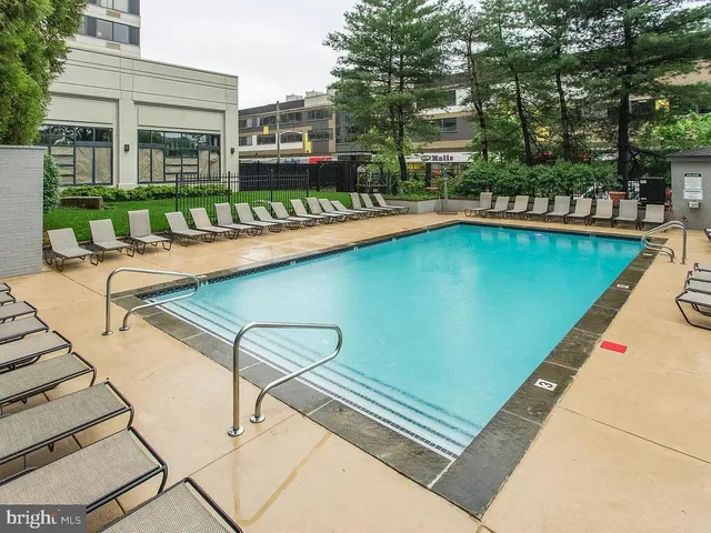 a view of swimming pool with outdoor seating and a garden