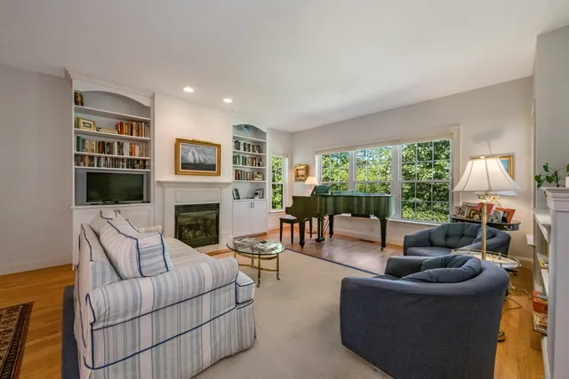 a living room with furniture fireplace and a large window