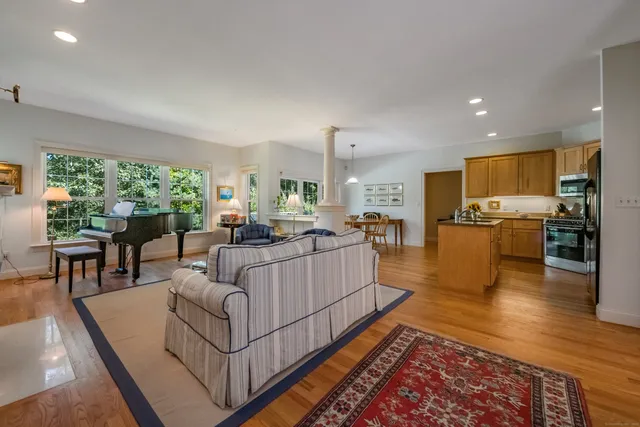 a living room with furniture wooden floor and a large window