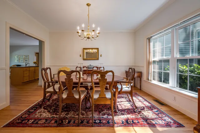 a view of a dining room with furniture a rug and wooden floor