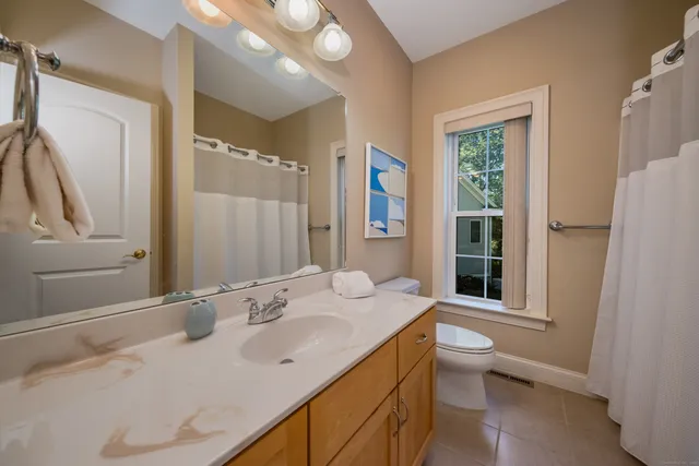 a bathroom with a granite countertop sink toilet and shower