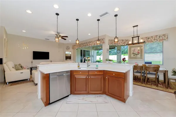 a kitchen with kitchen island granite countertop a stove a sink a refrigerator and a granite counter tops