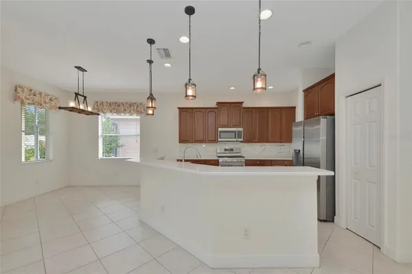 a kitchen with kitchen island a counter top space a sink stainless steel appliances and cabinets