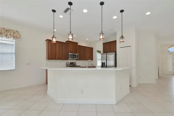 a view of kitchen with stainless steel appliances granite countertop a sink a refrigerator and a granite counter tops
