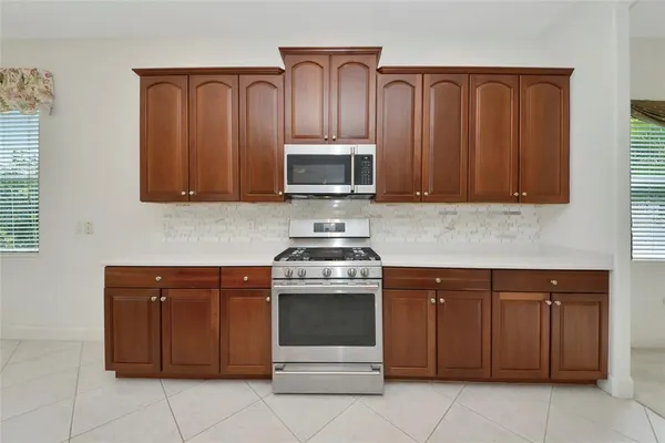 a kitchen with granite countertop wooden cabinets and stainless steel appliances