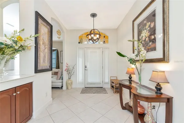a view of a hallway with furniture and a chandelier