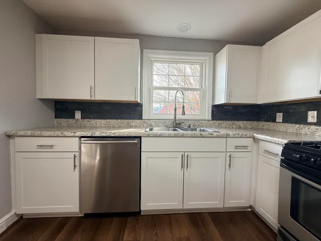 a kitchen with granite countertop white cabinets and white appliances