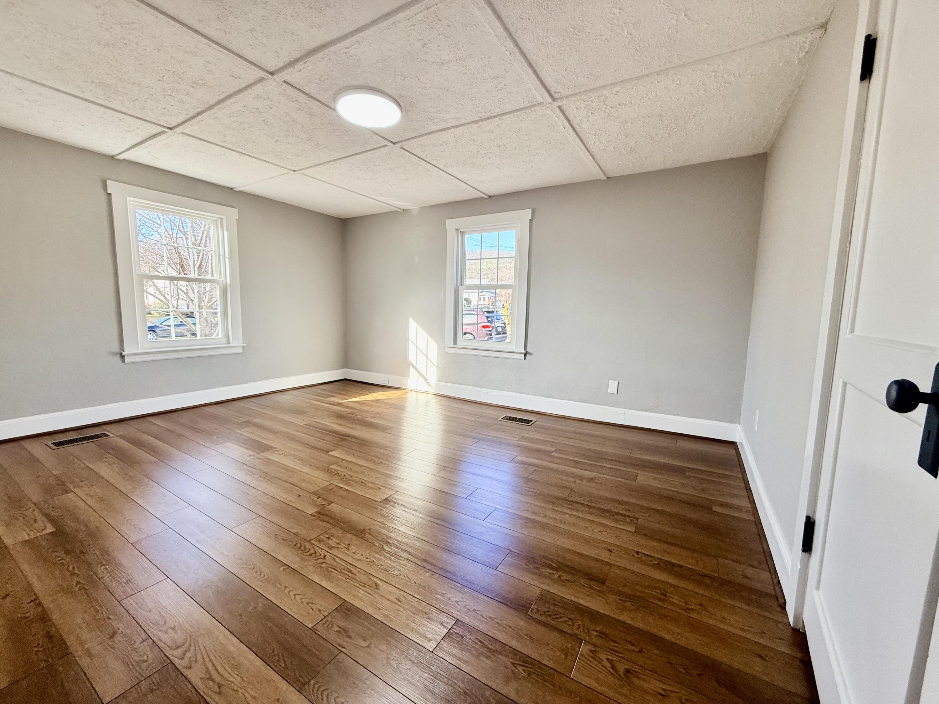 402 Goodwin Avenue Salem, VA 24153 - Photo 6 of 10 an empty room with wooden floor and windows
