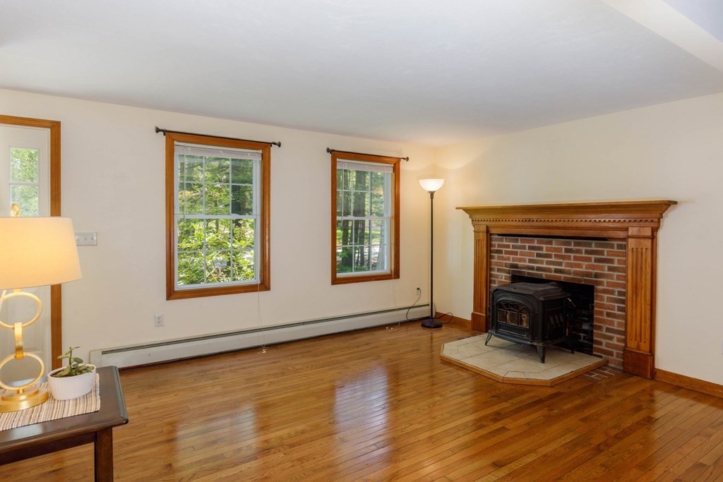101 Holt Road Ashburnham, MA 01430 - Photo 5 of 22 a view of an empty room with wooden floor fireplace and a window