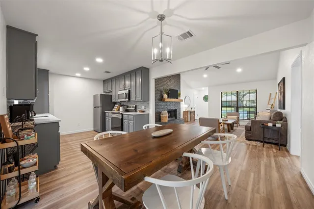 a view of a dining room with furniture a kitchen and chandelier