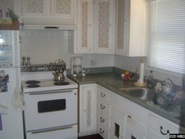 523 West 11th Street Reno, NV 89503 - Photo 2 of 9 a kitchen with granite countertop white cabinets and white stove