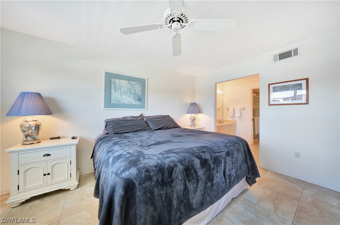 220 Coldeway Drive, Unit 112 Punta Gorda, FL 33950 - Photo 17 of 50 a bedroom with a bed and a chandelier