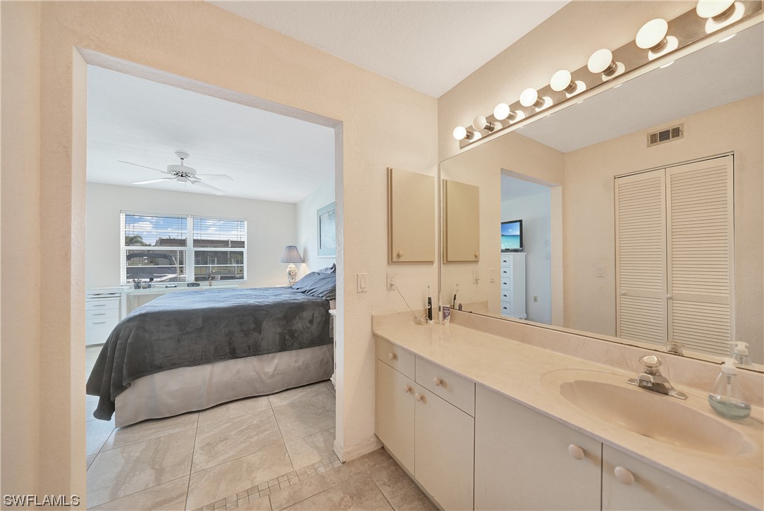220 Coldeway Drive, Unit 112 Punta Gorda, FL 33950 - Photo 20 of 50 a en suite bathroom with double vanity and a mirror