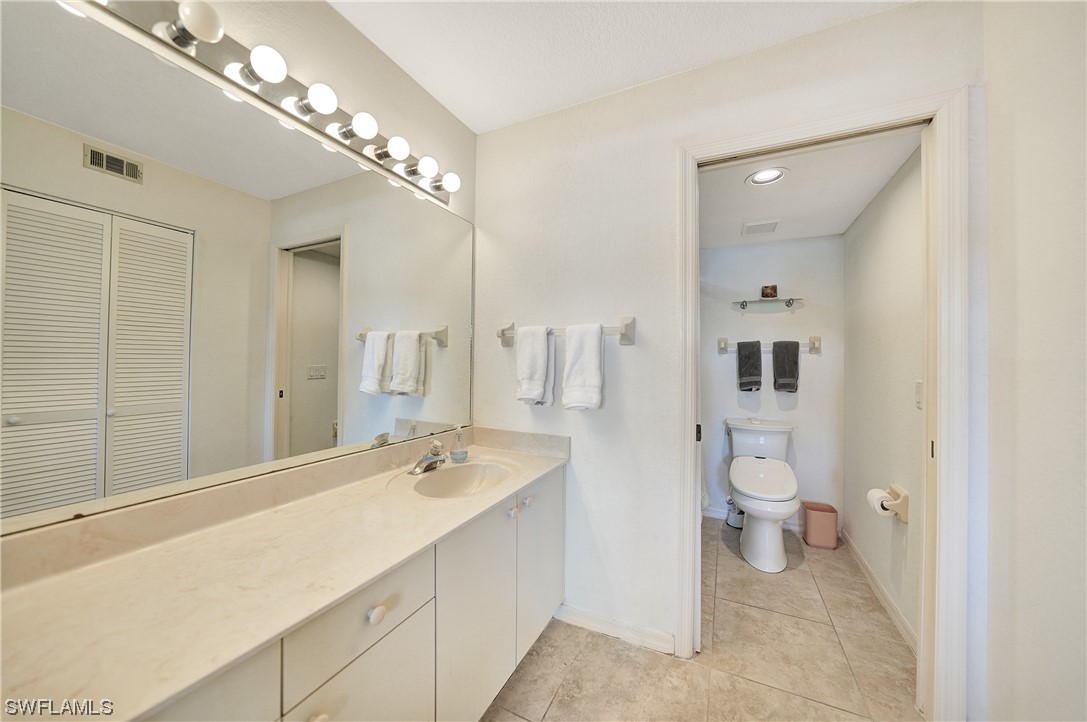 220 Coldeway Drive, Unit 112 Punta Gorda, FL 33950 - Photo 21 of 50 a spacious bathroom with a double vanity sink a mirror and a toilet