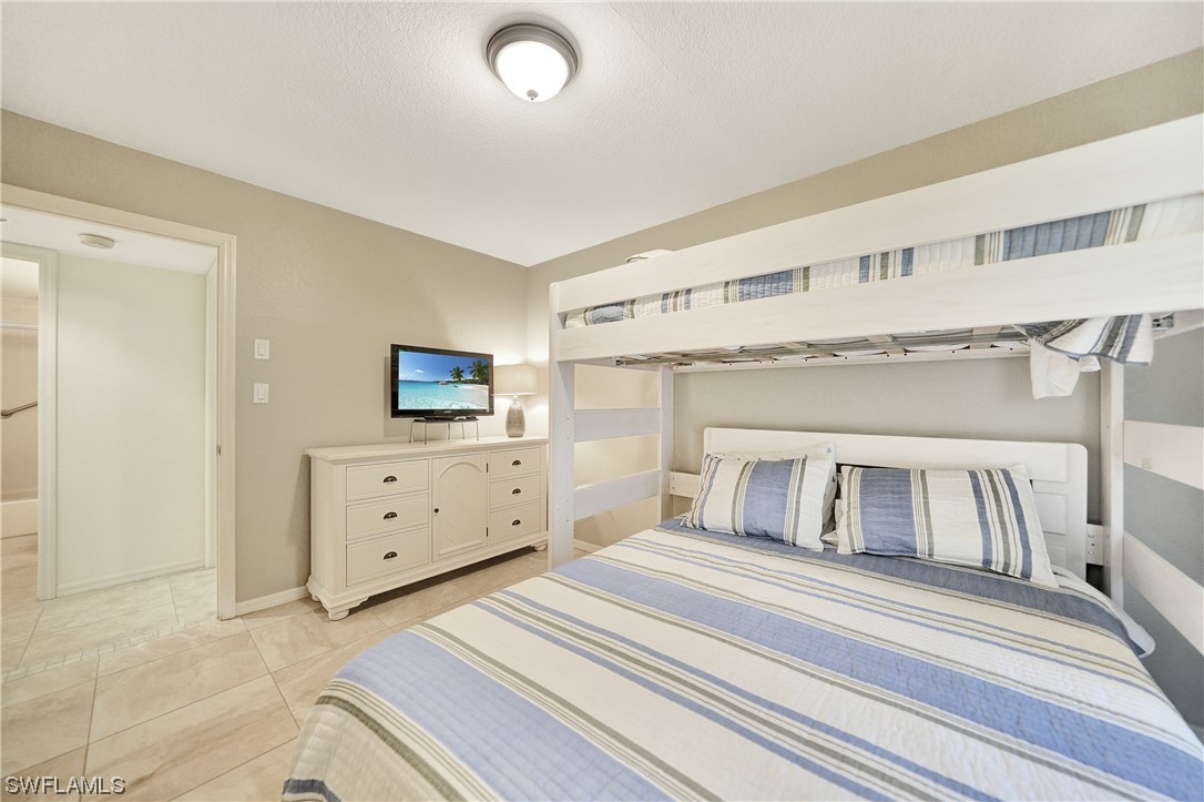 220 Coldeway Drive, Unit 112 Punta Gorda, FL 33950 - Photo 25 of 50 a bedroom with a bed and a flat tv screen on dresser