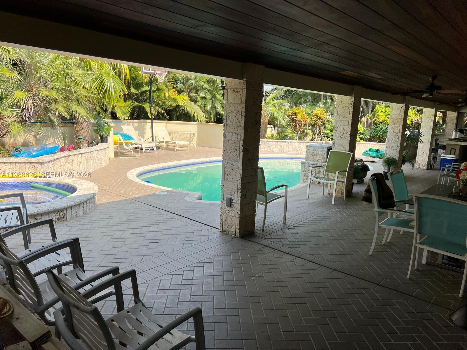 30705 Southwest 197th Avenue Homestead, FL 33030 - Photo 13 of 17 a view of a patio with chairs and floor to ceiling window